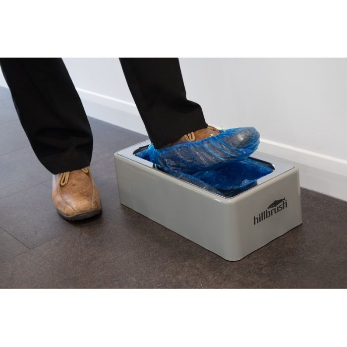 Automatic Shoe Cover Dispenser AD1 - DG115 in use, applying a blue cover to a shoe.